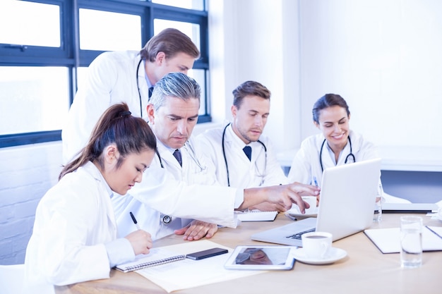 Medical team looking into laptop and having a discussion at conference room