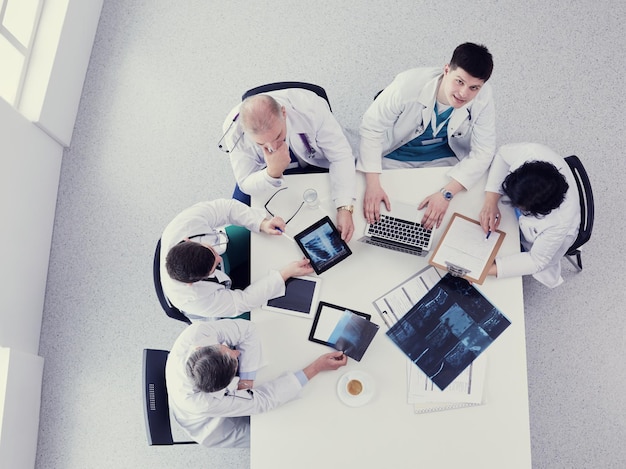 Medical team sitting and discussing at table top view