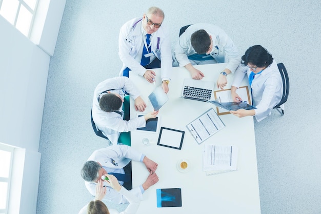 Medical team sitting and discussing at table top view