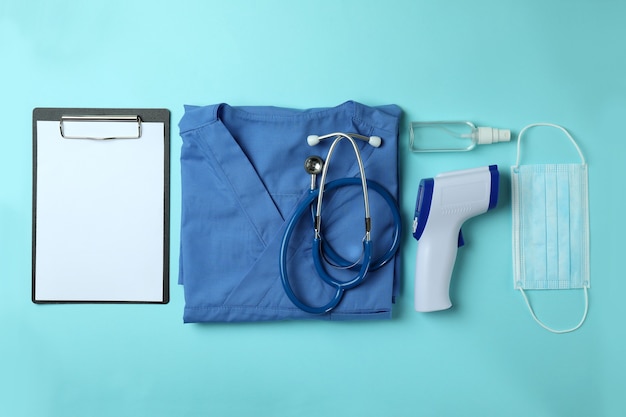 Medical tools and thermometer gun on blue