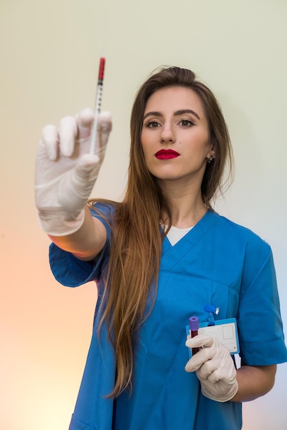 Medical worker holding syringe and wearing blue uniform. Ready for injection