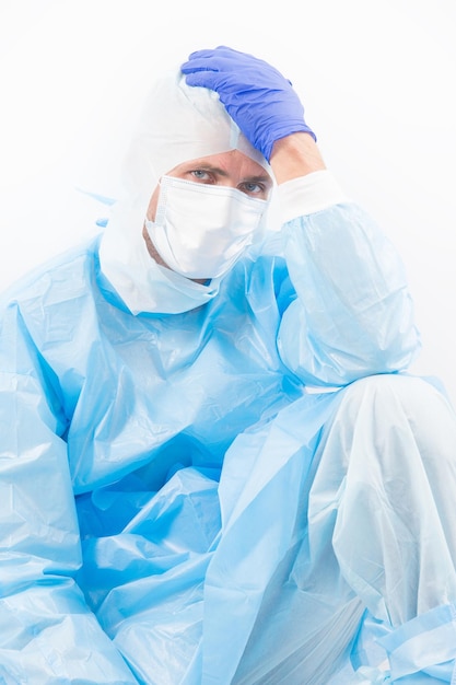 Medical worker man in protective costume isolated on white having covid19 sars virus symptoms of headache, coronavirus pandemic.