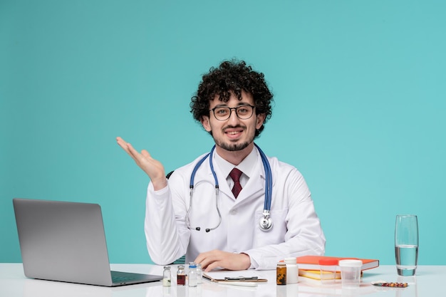 Medical young serious handsome doctor working on computer in lab coat waving hands