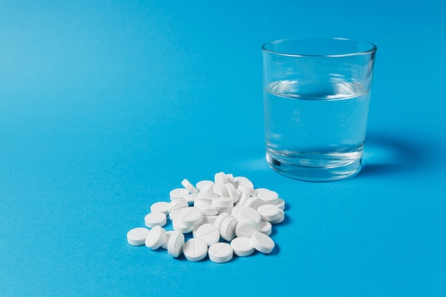 Medication pile white round tablets arranged abstract on blue color background