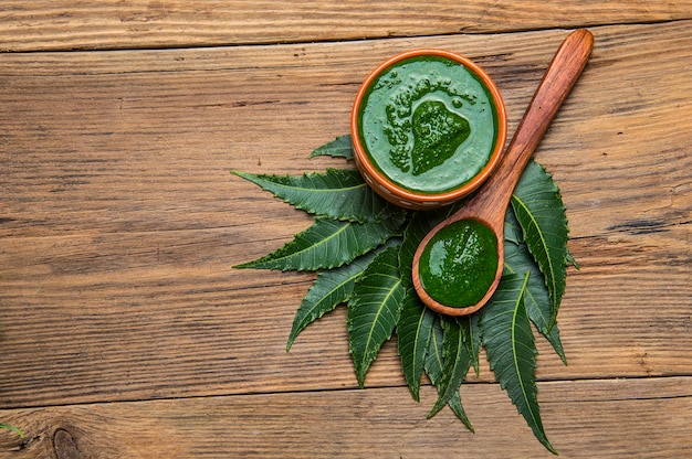 Medicinal Neem leaves with paste on wooden background