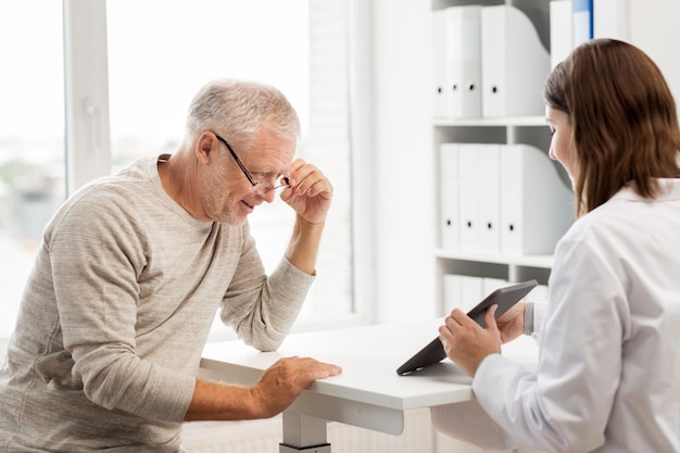 medicine, age, health care and people concept - senior man and doctor with tablet pc computer meeting in medical office at hospital