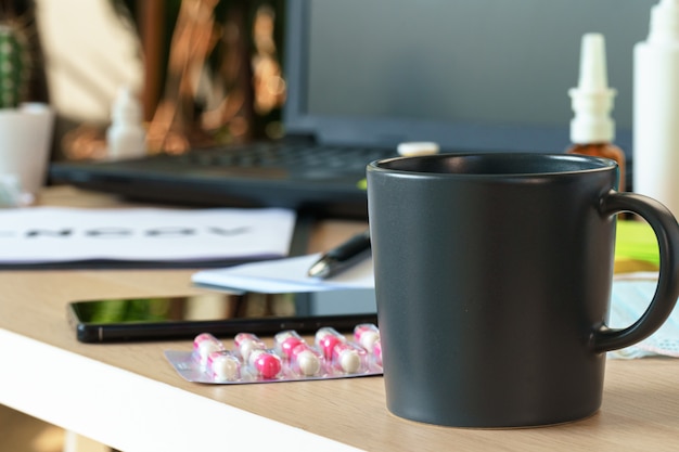 Medicine bottle on an office table with laptop close up