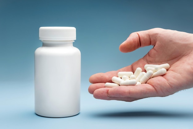 Medicine bottle and palm with capsules closeup