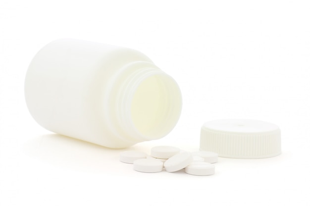 Medicine bottle and white pills isolated on white background