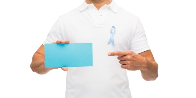 medicine, health care, gesture and people concept - close up of middle aged latin man in t-shirt with sky blue prostate cancer awareness ribbon holding blank paper card