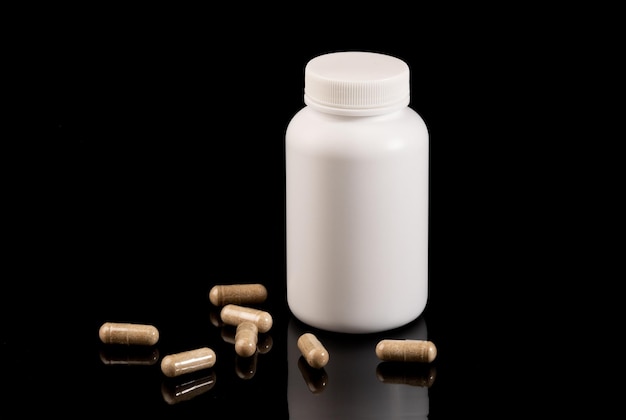 Medicine and health concept Pills and a jar lie on a black background