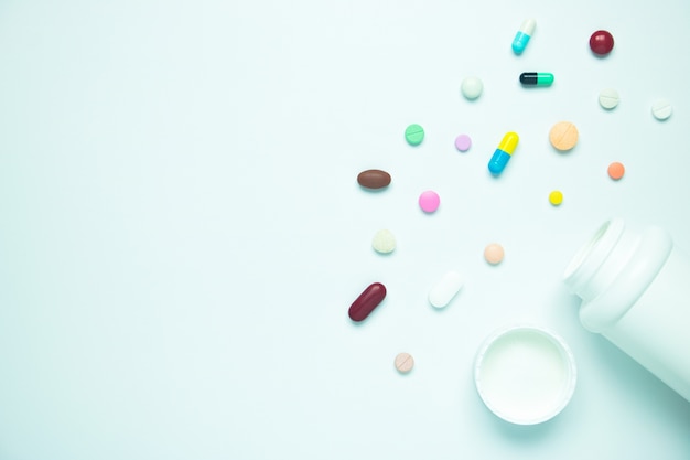 Medicine pill and plastic bottle on white background