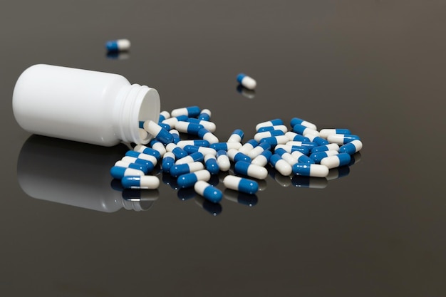 Medicine pills on black surface Medicine bottle lying on the table Selective focus