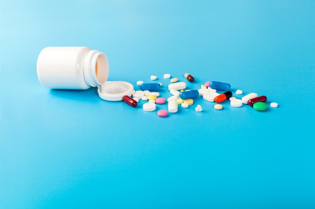 Medicine pills and capsules on blue background