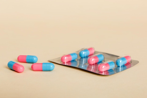 Medicine pills on a light background Medicines and prescription pills flat lay background Blue and pink medical tablets in blister