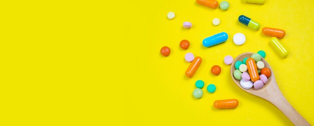 Medicines, pills, mask, virus, on a yellow background. Selective focus