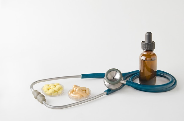 Medicines and stethoscope on light gray background