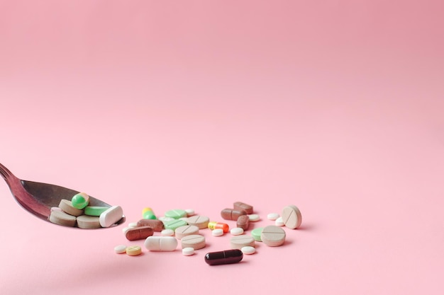 Medicines with spoon isolated on pink background Creative concept with copy space for healthcare