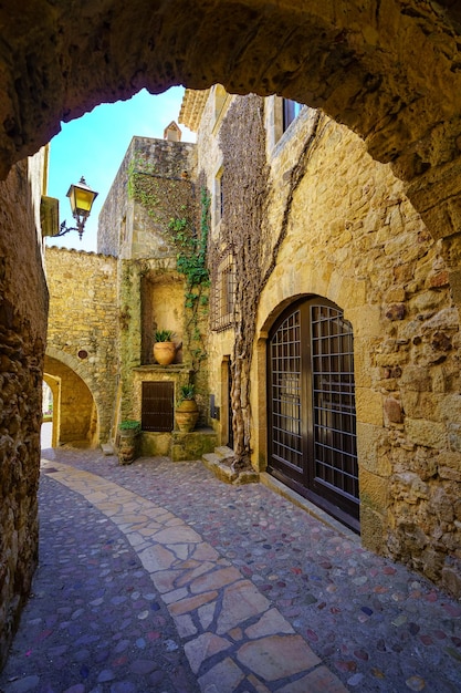 Medieval alley with stone houses and arches in the picturesque town of Pals Girona Spain