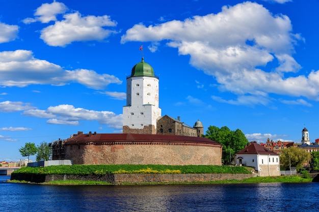 Medieval fortress in Vyborg Castle on the water against the blue sky with clouds