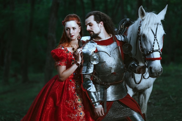 Medieval knight with his beloved lady in red dress