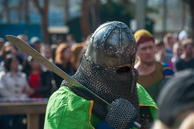 Medieval restorers fight with swords in armor at a knightly tournament historical restoration of kni