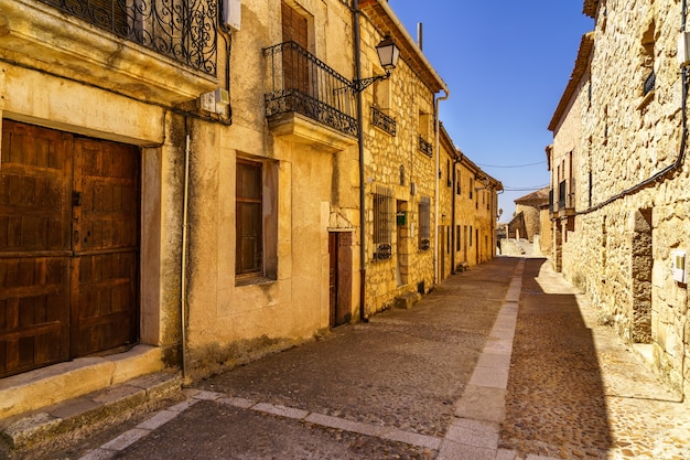 Medieval village with stone houses, cobblestone streets, old doors and windows, arches and walls. Maderuelo Segovia Spain.