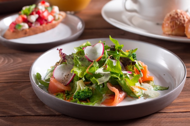 Mediterranean cuisine. Salad. Slices of salmon with fresh vegetable salad on a plate.