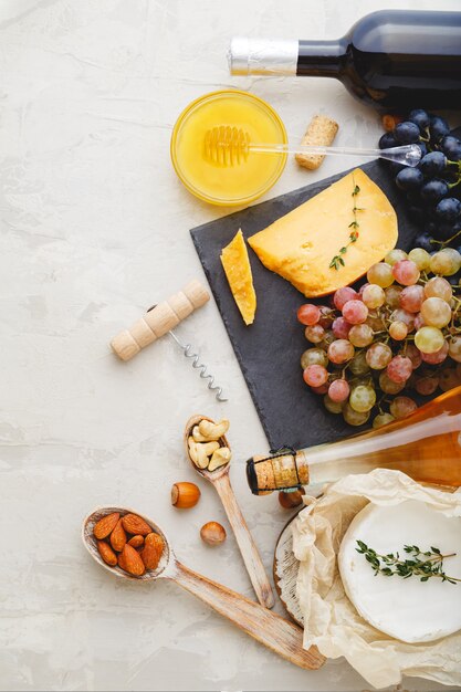 Mediterranean food drinks Ingredients set for dinner. Wine honey cheese nuts snacks bread grapes fruit on Light gray stone background. Gastronomy natural food and drink products.