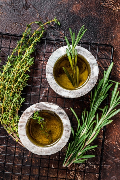 Mediterranean ingredients olive oil thyme and rosemary Top view Dark background