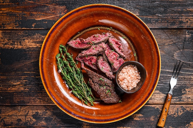 Medium rare Sliced grilled Onglet Hanging Tender meat beef steak on a plate