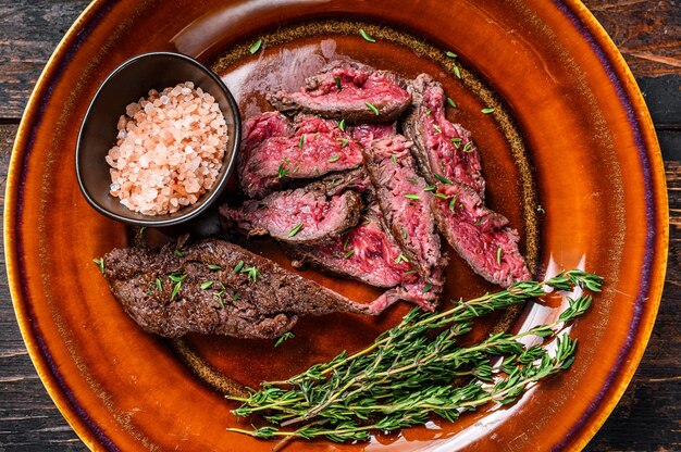 Medium rare Sliced grilled Onglet Hanging Tender meat beef steak on a plate