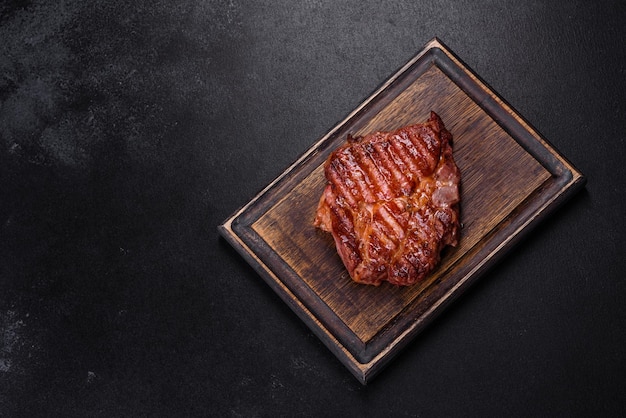 Medium rare sliced grilled striploin beef steak served on wooden board