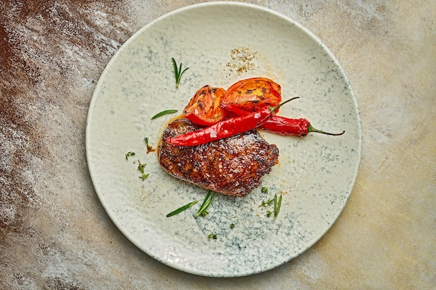 Medium rare steak on a white plate with spices Closeup selective focus