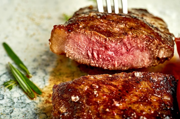 Medium rare steak on a white plate with spices Closeup selective focus