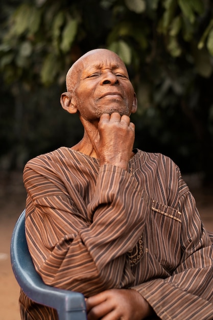 Medium shot african man sitting outdoors