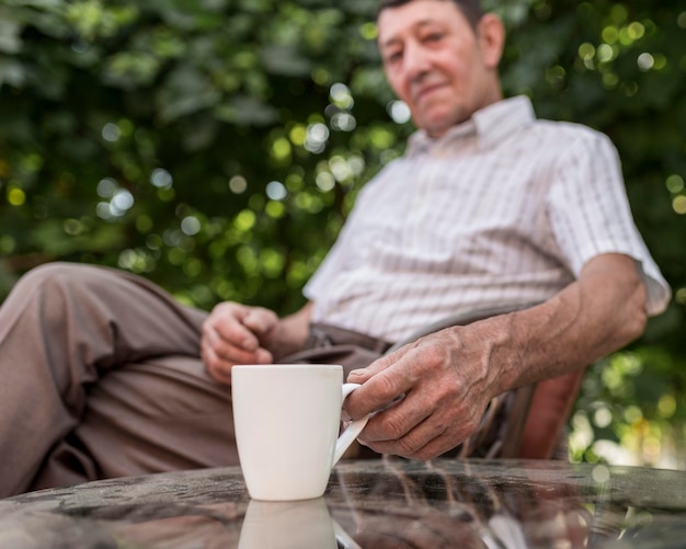 Medium shot blurred man holding mug