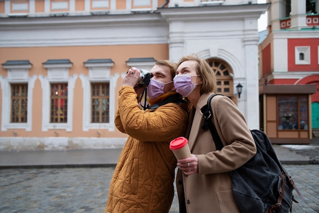 Medium shot couple taking photos with camera