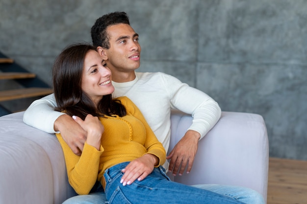 Medium shot of couple watching tv