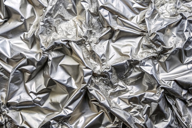 A medium shot of a crumpled foil with a shiny silver surface perfect for decorating backgrounds and adding a touch of elegance to any project metallic reflective shiny surface