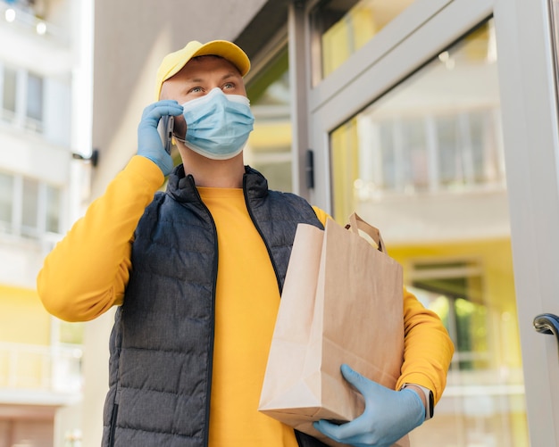 Medium shot delivery man holding bag