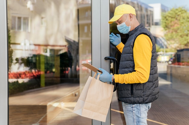 Medium shot delivery man holding bag