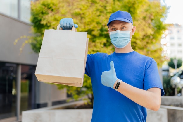 Medium shot delivery man holding bags