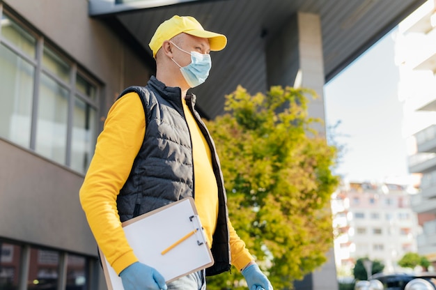 Medium shot delivery man wearing mask