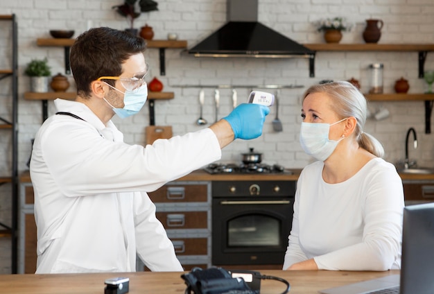 Medium shot doctor checking woman's temperature