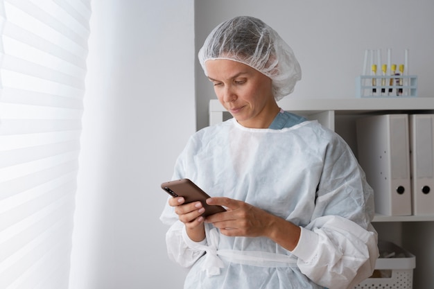 Medium shot doctor holding smartphone