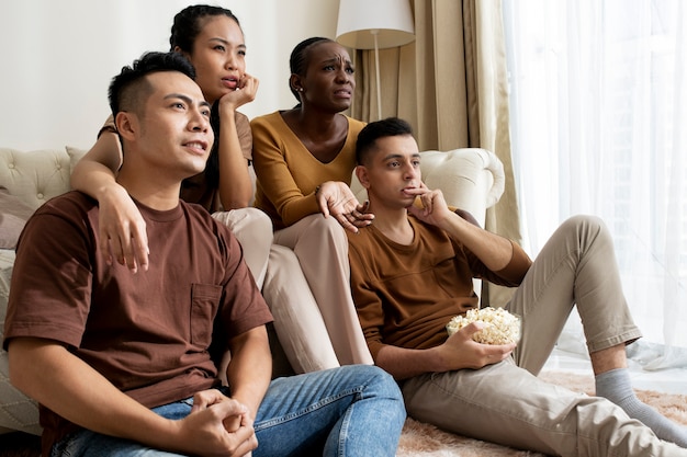 Medium shot friends watching movie together