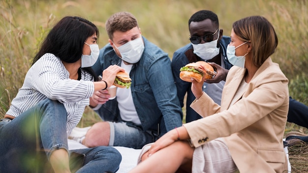 Medium shot friends with burgers and masks