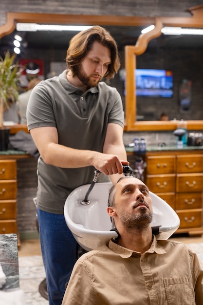 Medium shot hairdresser washing man's hair