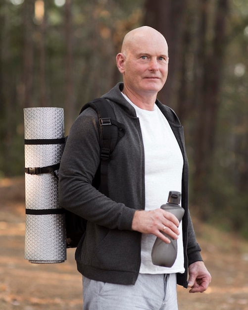 Medium shot man carrying yoga mat